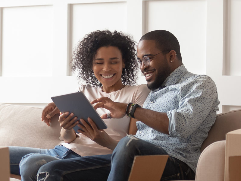 A couple are looking at their tablet